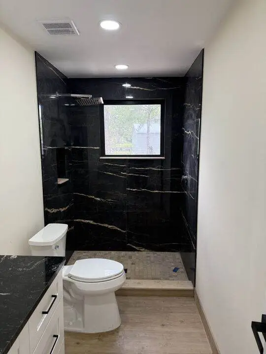 Bathroom with black marble look shower walls