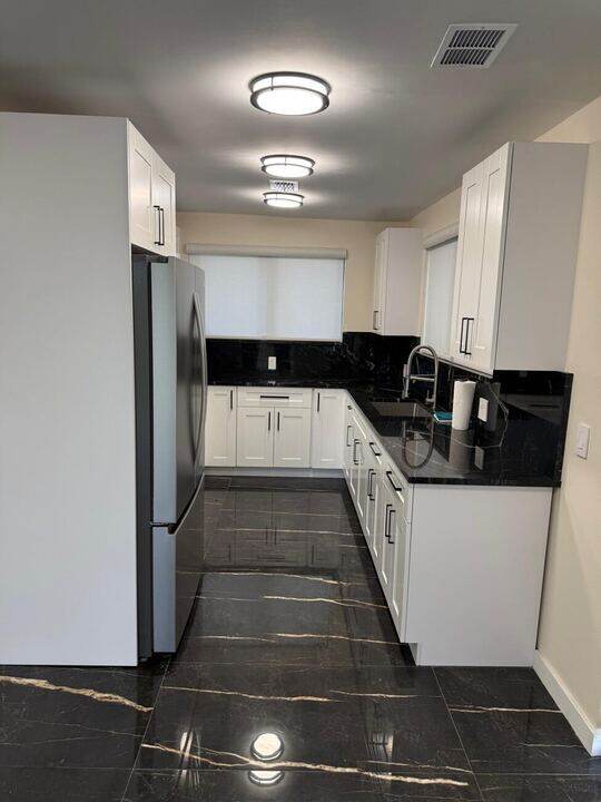 New kitchen with white cabinets and black granite