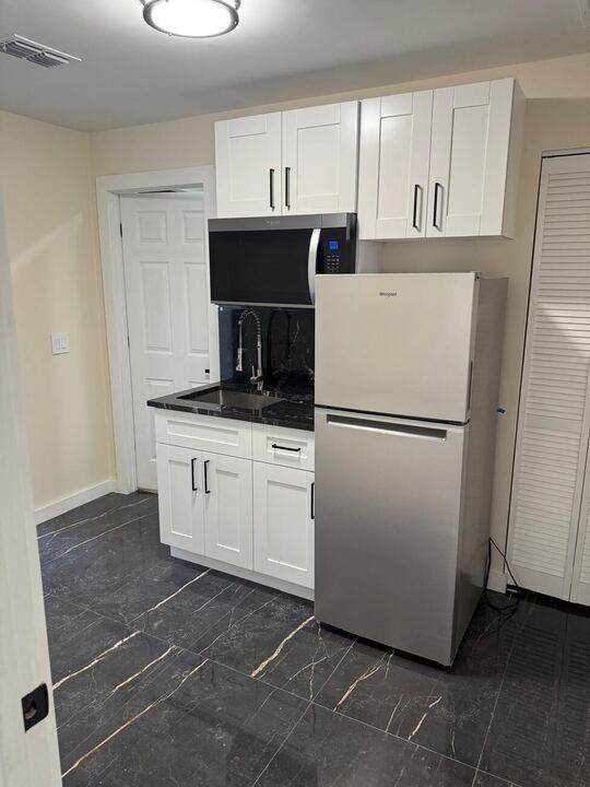 Kitchenette with white cabinets
